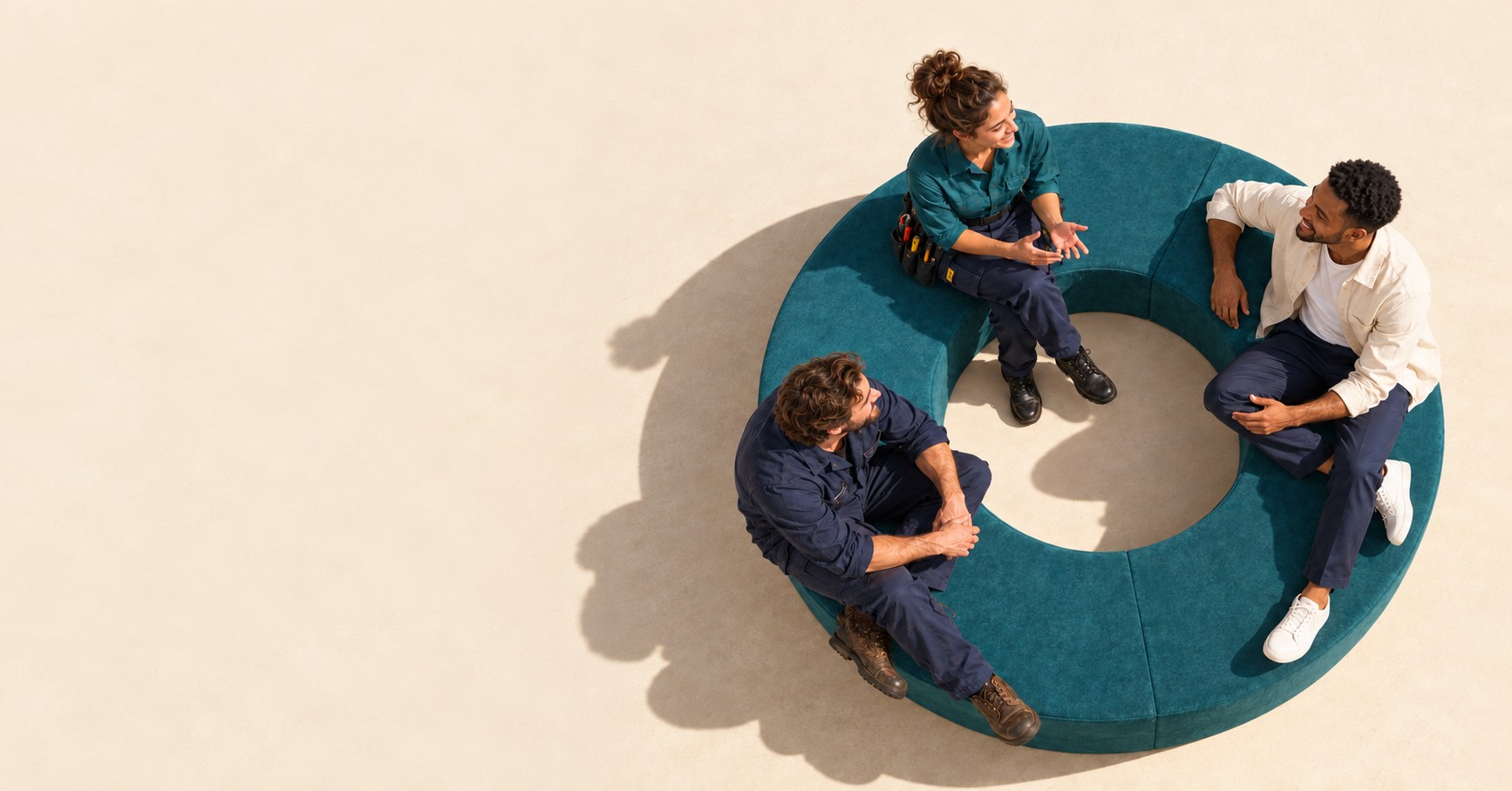 Colleagues from different workplaces talking together on a sculptural teal circular bench.